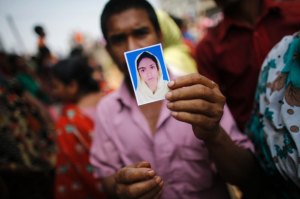 A relative holds a picture of a missing garment worker, who was working in the Rana Plaza when it collapsed, in Savar